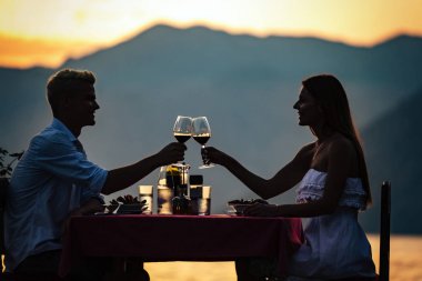 Mutlu genç çift yaz akşamında romantik bir akşam yemeği yiyor.