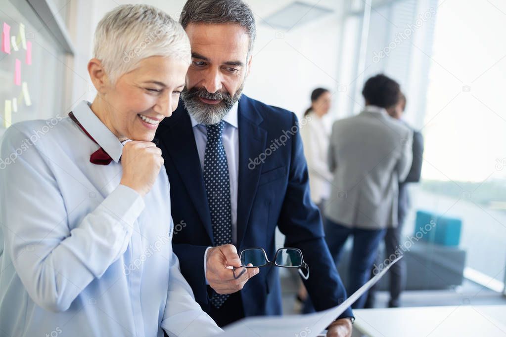 Portrait of happy business people discussing together in modern office