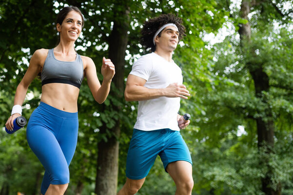 Couple friends jogging and running outdoors in nature