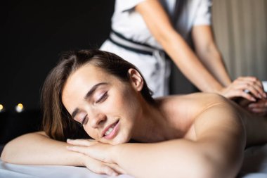 Masör spa salonunda kadın vücuduna masaj yapıyor. Güzellik kaplıcası tedavi konsepti.