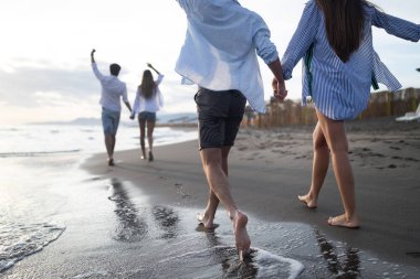 Mutlu mutlu çift gün batımında tropik bir plajda eğleniyor. Romantik tatil kavramı