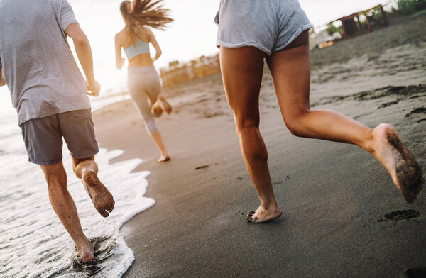 Group of happy sport people jogging on the beach