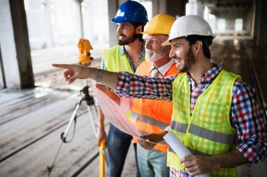 İnşaat mühendisi mimar ustabaşıyla inşaat alanını kontrol ediyor.