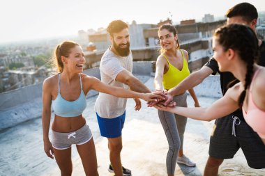 Bir grup zinde insan çatıda antrenman yapıyor.