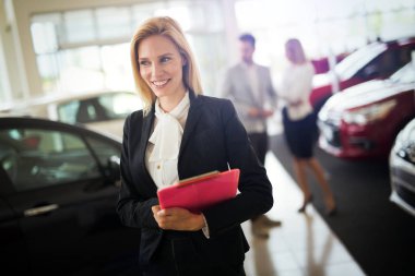 Araç showroom içinde duran güzel genç pazarlamacı portresi