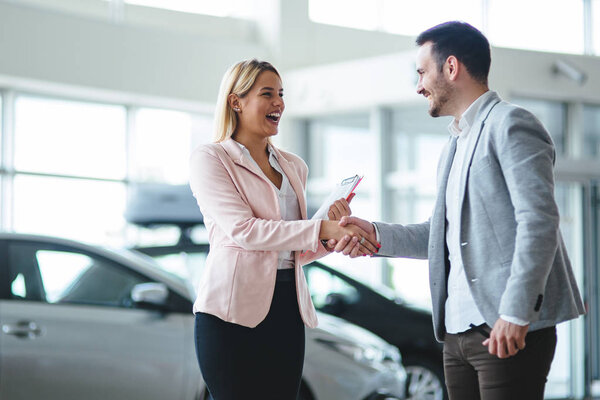 Portrait of happy young customer buying new car