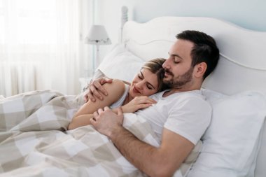 Yatak odasında genç çekici sevgi dolu çift portresi