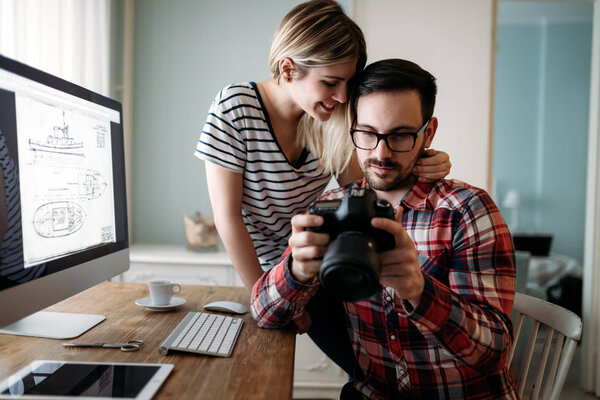 Молодые привлекательные графические дизайнеры, работающие над проектом вместе
