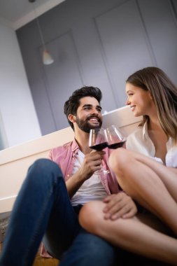 Güzel bir çift yatak odasında birlikte vakit geçirirken gülümsüyor, konuşuyor ve sarılıyor.