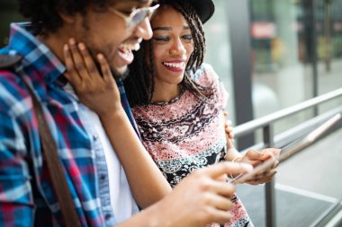 Genç çekici Afrika Amerikan çift konuşan ve dijital tablet bakıyor.