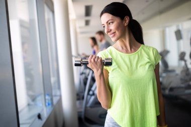 Spor salonundaki çekici, formda genç kadın imajı.