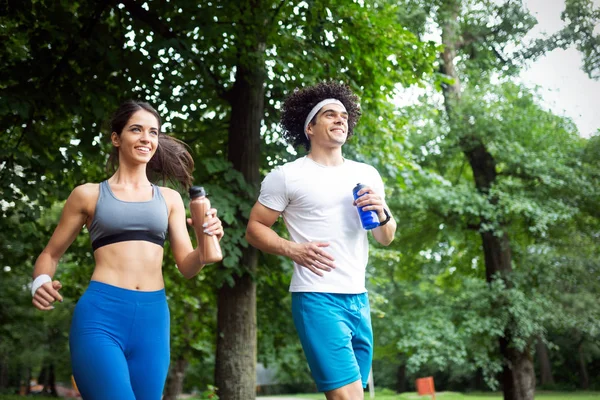 Genç insanlar sağlıklı kalmak için doğada koşuyor ve egzersiz yapıyorlar.