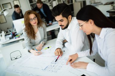 Bir grup mimar ve iş adamı birlikte çalışıyor ve beyin fırtınası yapıyorlar.