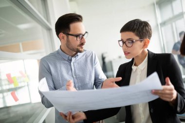 Bir grup mimar ve iş adamı birlikte çalışıyor ve beyin fırtınası yapıyorlar.