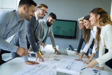 Takım inşaat planları üzerinde birlikte çalışan mimarlar