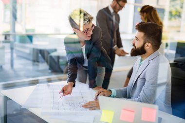 Genç Mimarlar modern ofiste tartışırken resmini