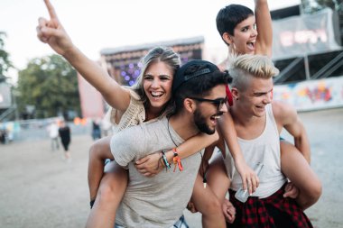 Mutlu genç arkadaşlar müzik festivalinde eğleniyor.