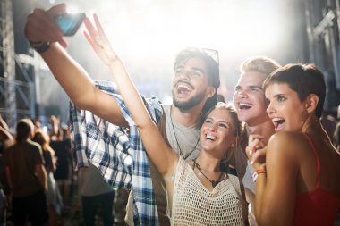 Mutlu genç arkadaşlar müzik festivalinde eğleniyor.