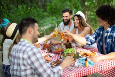 Arkadaşlar doğada barbekü partisi verip eğleniyorlar.