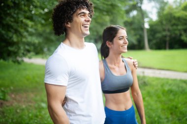 Mutlu genç kadın bir parkta açık egzersiz yapıyor, koşu