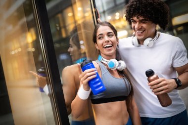 Fitness, spor, arkadaşlık ve yaşam tarzı kavramı-gülümseyen çift jogging açık