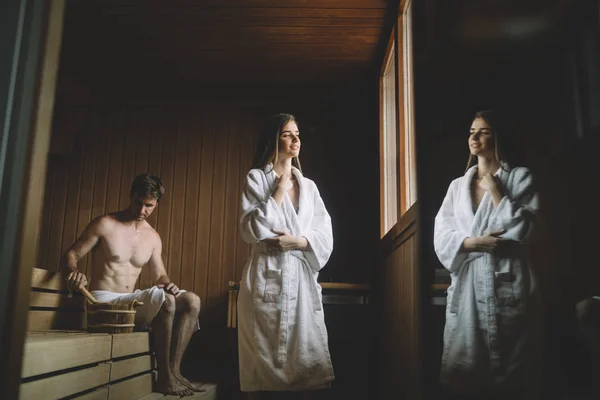 Beautiful young woman relaxing in sauna and staying healthy