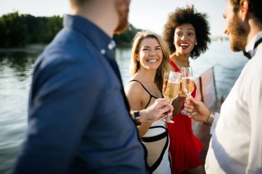 Bir grup mutlu insan ya da arkadaş partide eğleniyor ve gülümsüyor.