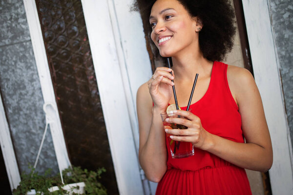 Beautiful black woman drinking healthy drink and smiling