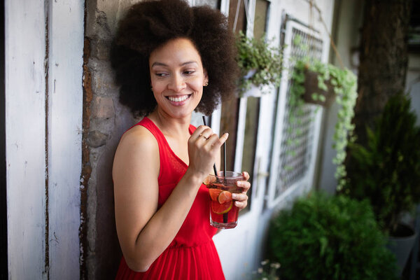 Beautiful black woman drinking healthy drink and smiling