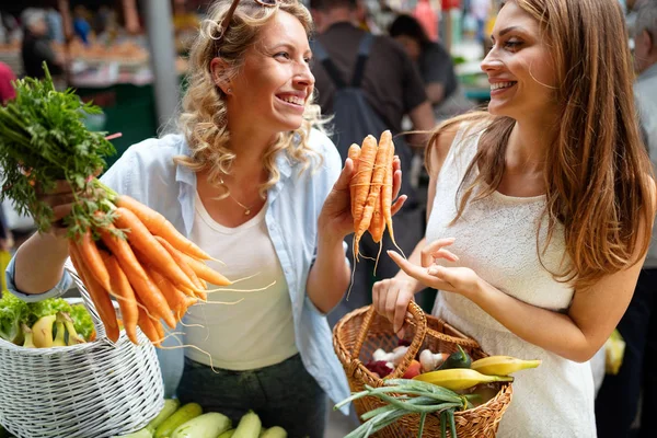 시장에서 채소와 과일을 즐기는 행복한 친구들 — 스톡 사진
