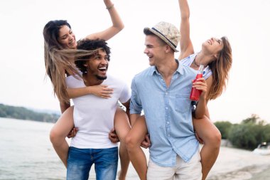 Plajda eğleniyor genç arkadaşlar grubu. Yaz, tatiller, tatil konsepti.