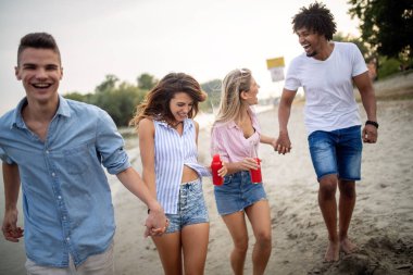 Bir grup arkadaş yaz partisinde kumsalda harika vakit geçiriyorlar.