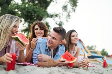 Bir grup arkadaş yaz partisinde kumsalda harika vakit geçiriyorlar.