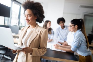 Ofiste çalışan ve beyin fırtınası yapan mutlu iş adamları