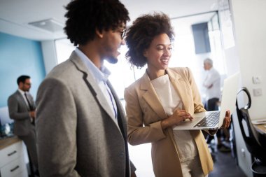 Ofiste çalışan ve beyin fırtınası yapan mutlu iş adamları
