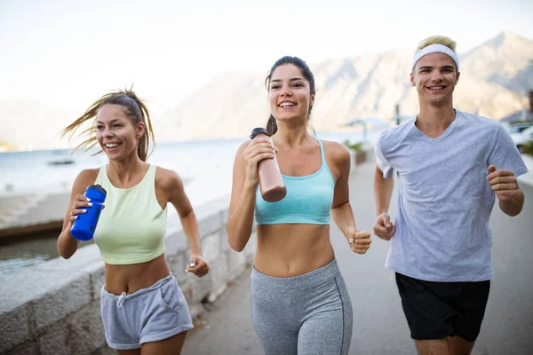 Healthy fit people running and jogging together in summer sunny nature