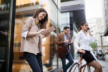 Genç ve mutlu iş adamlarına bakın dışarıda konuşuyorlar ve gülümsüyorlar.