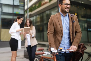 Mutlu iş arkadaşları konuşuyor, gülümsüyor ve şehirde yürüyor.