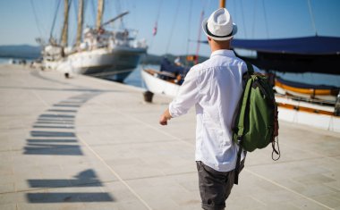 Tatil, tatil, seyahat, deniz ve insan kavramı. Sırt çantası ile Adam seyahat zevk