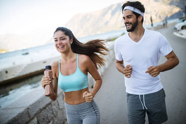 Glücklich fitte Menschen laufen und joggen zusammen in sommerlicher sonniger Natur — Stockfoto