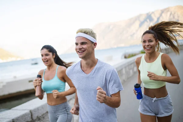 Happy Fit människor springa och jogga tillsammans på sommaren solig natur — Stockfoto