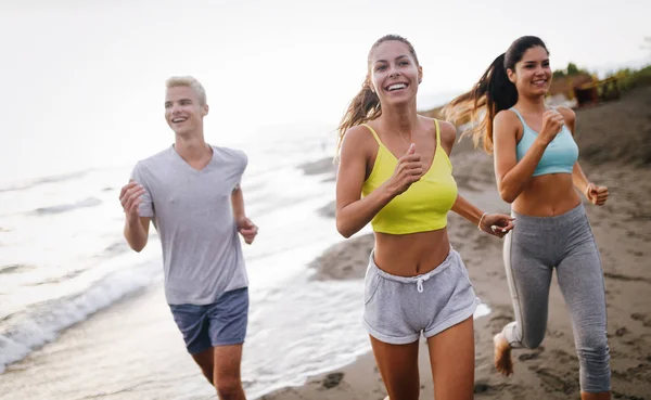 Group of sport people jogging on the beach