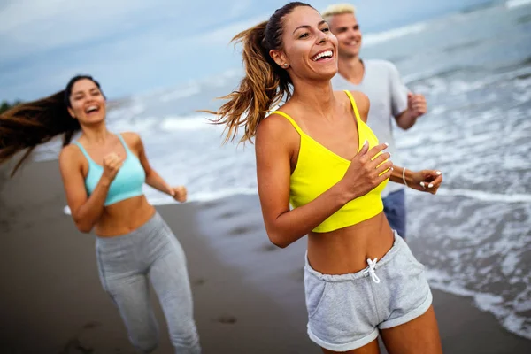Group of sport people jogging on the beach