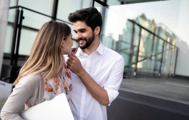 Mutlu genç çift dışarıda sarılıp gülüyor.