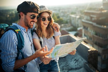 Young couple traveling with a map in the city clipart