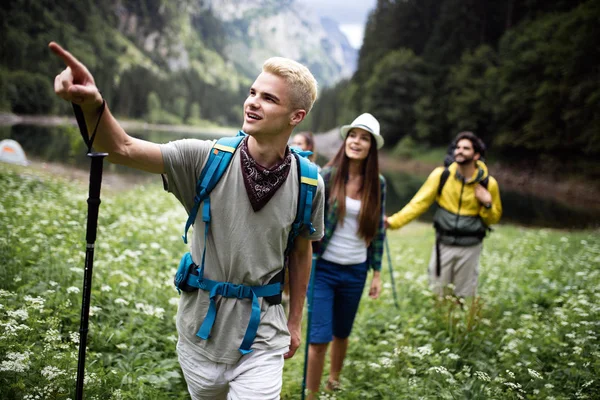 Group of young friends hiking in countryside. Multiracial happy people traveling in nature