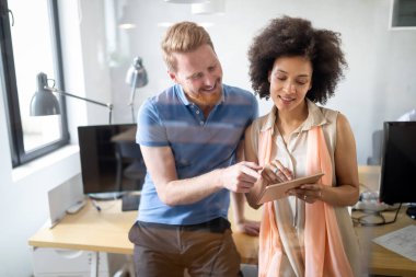 Ofiste iş arkadaşlarıyla birlikte çalışan ve iletişim kuran bir grup iş adamı.