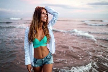 Gün batımında sahilde güzel bir kız. Yaz tatili konsepti