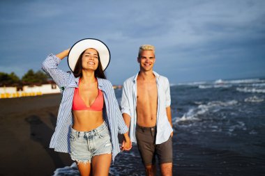 Mutlu romantik çift kumsalda eğleniyor ve sevişiyor.