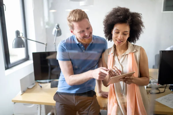 Ofiste iş arkadaşlarıyla birlikte çalışan ve iletişim kuran bir grup iş adamı.